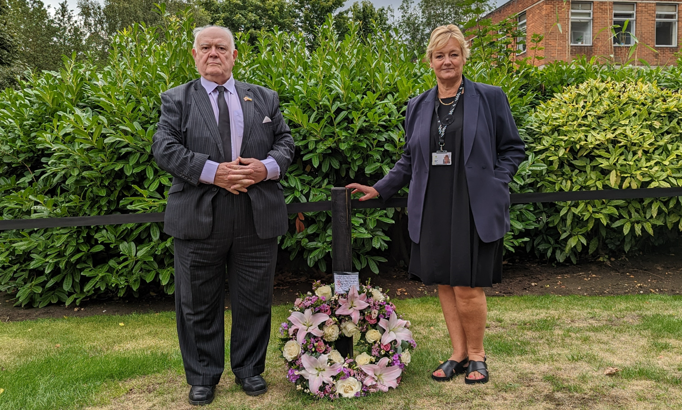 Image entitled Ashford Council Leader Cllr Gerry Clarkson and Chief Executive Tracey Kerly next to the first floral tribute at the Memorial Gardens