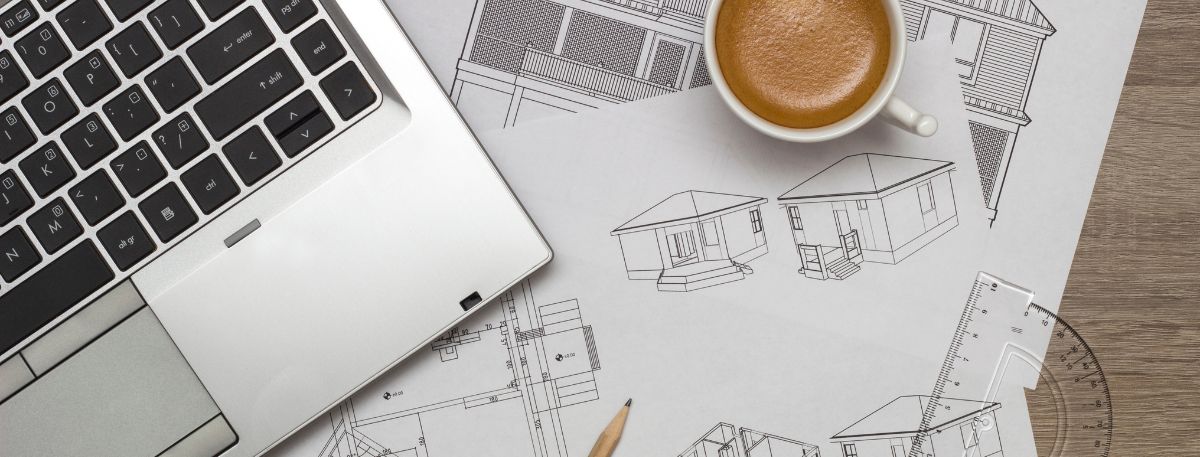 laptop, house drawings and a hot drink