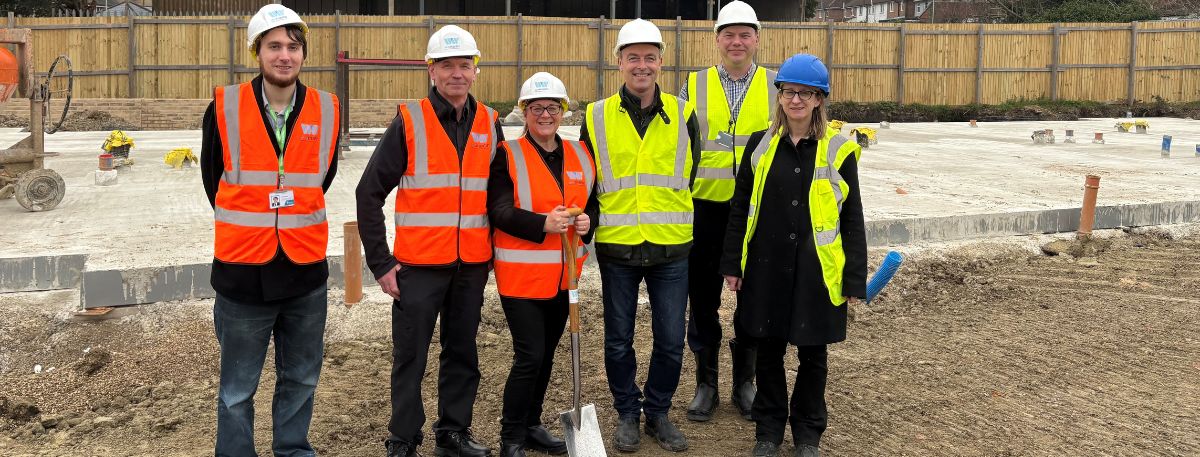 From L to R: Cllr Euan Anckorn, Cllr Noel Ovenden, Maria Stevens, Giles Holloway, Mark Bawden and Elizabeth Giles all in hi-vis gear, with Maria Stevens holding a spade outside the Mabledon development plot