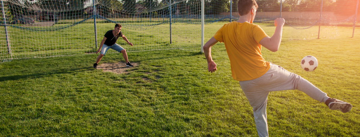 Two teenage boys playing football