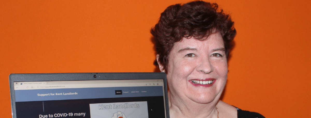 Head of Housing Sharon Williams holding a laptop with the Support for Kent Landlords website displayed on it.