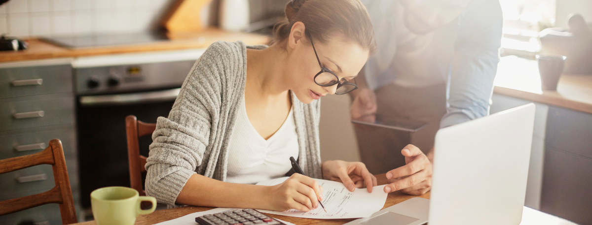 Couple looking at paperwork in front of a laptop