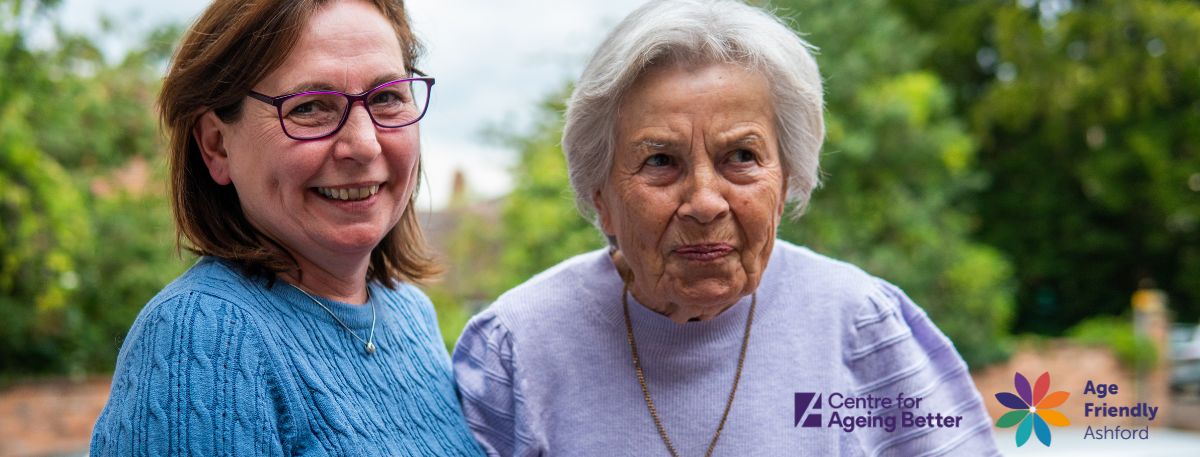 Two women over 50 smiling happily next to each other