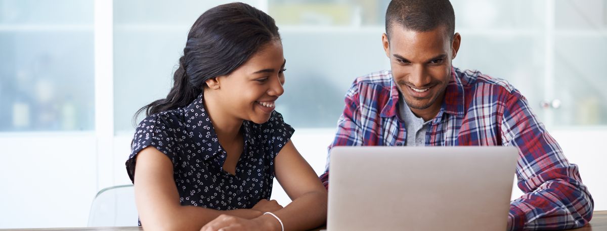 Two people looking at a laptop screen