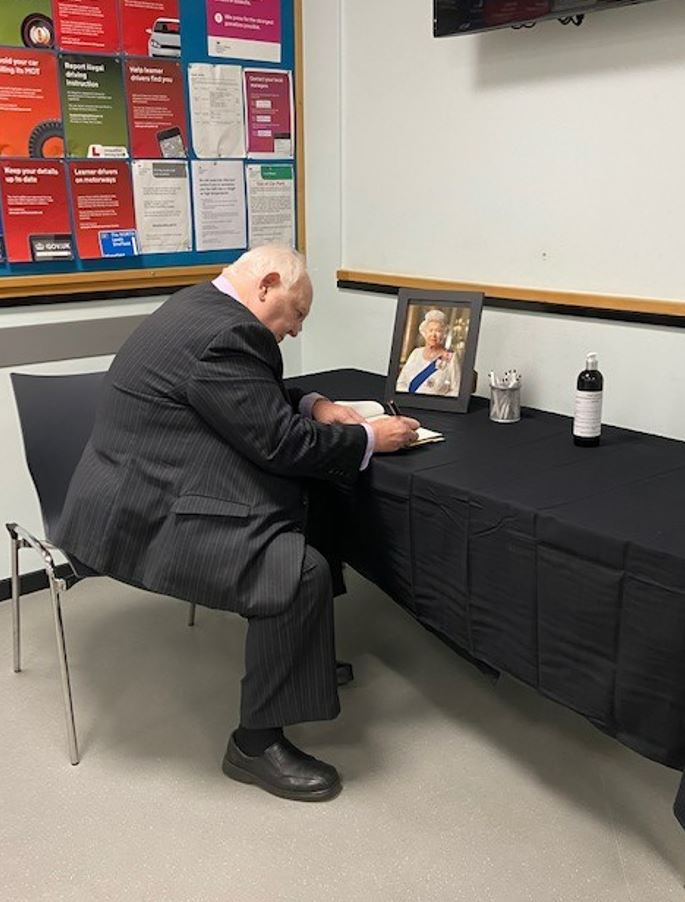 Image entitled Ashford Borough Council Leader Cllr Gerry Clarkson signing Ashford’s book of condolence at the Civic Centre