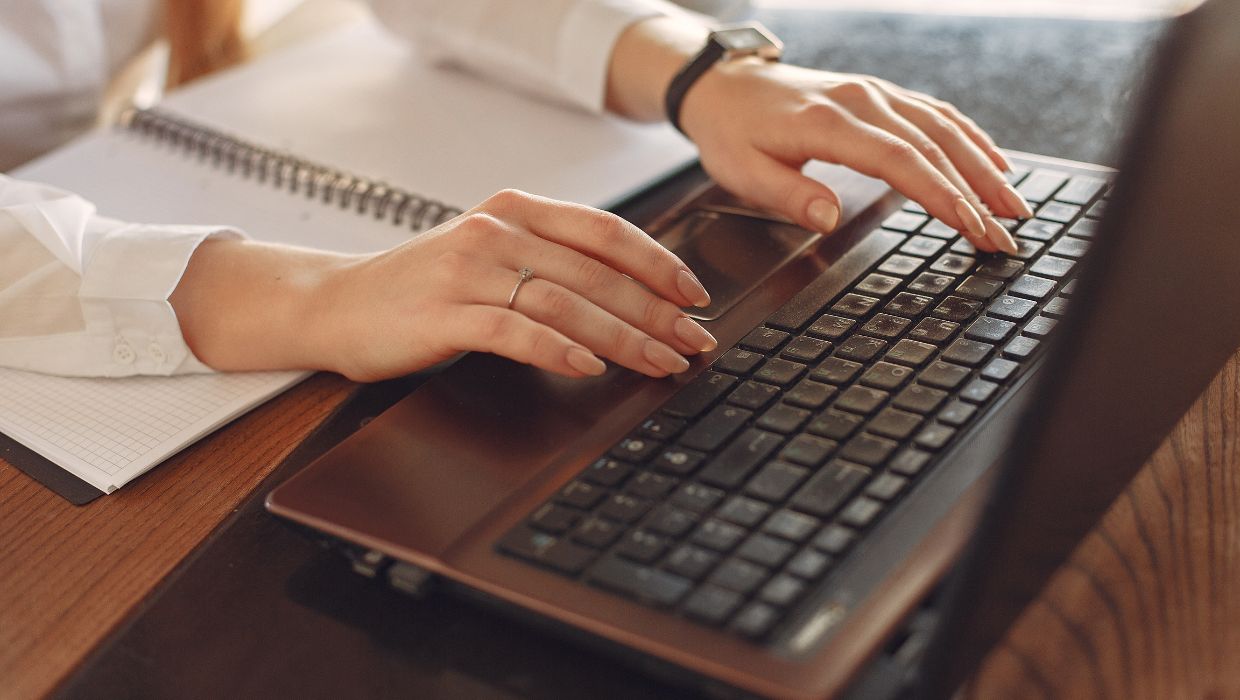 Person using a laptop to buy services online tile