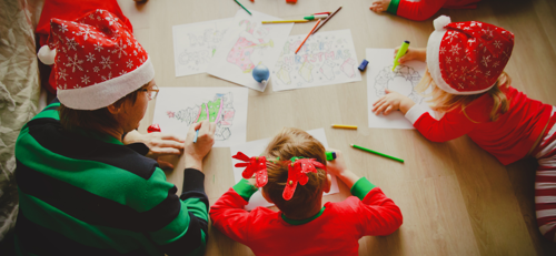 a family in santa hats colouring in