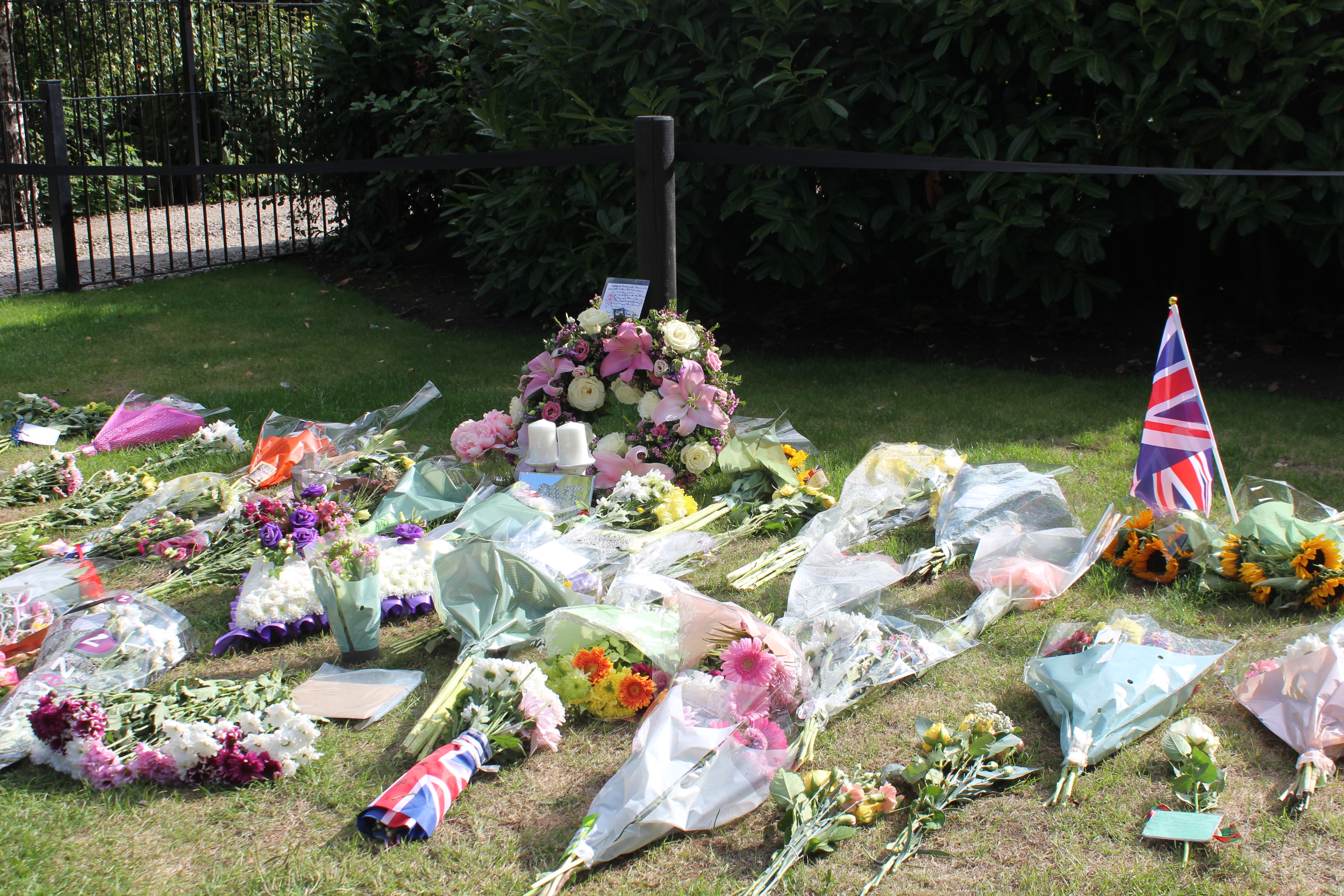 Image entitled Floral tributes to Her Majesty left by local residents at the Memorial Gardens in Ashford Town Centre