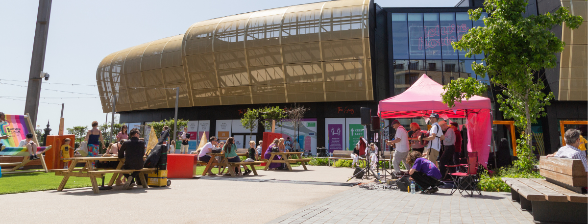 People enjoying live music outdoors during the Fabric of Ashford event at Elwick Place