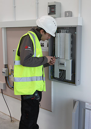 Image entitled Electrical Services Division Electrician Working On An Indoor Fuse Box