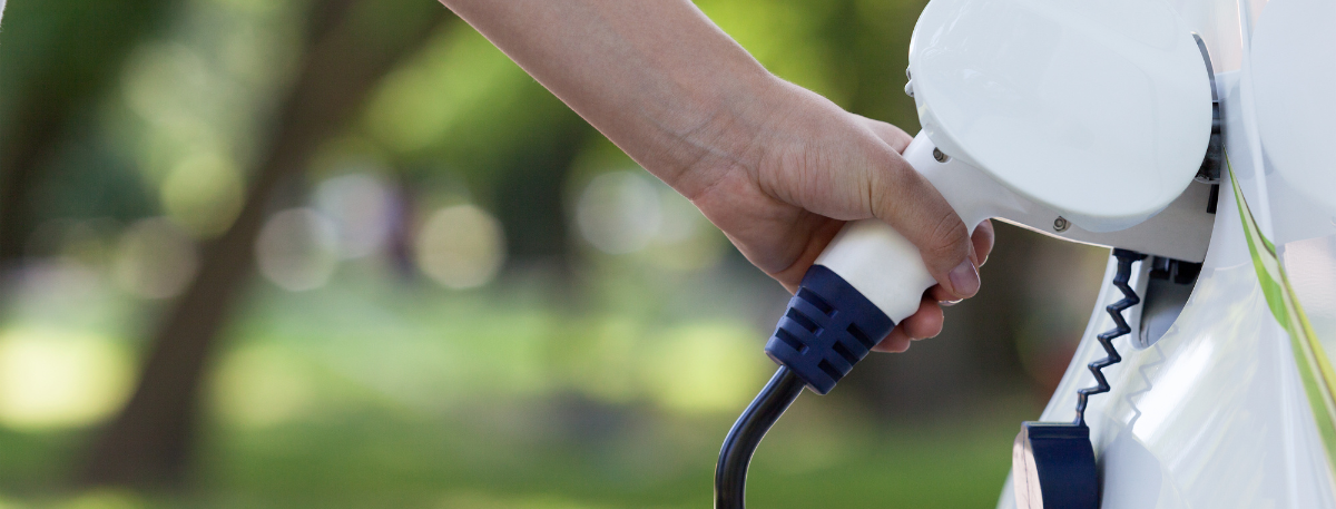 Electric vehicle charger being plugged in