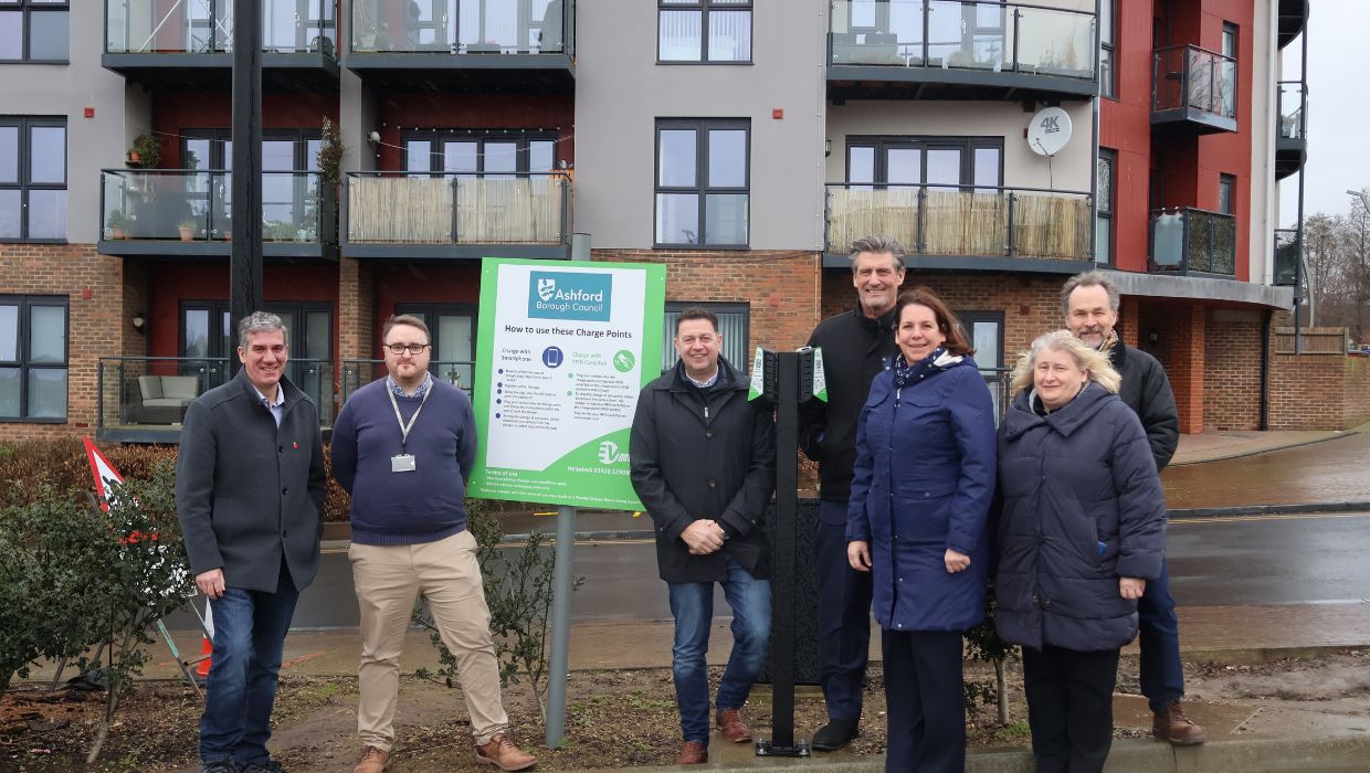 From left to right - Richard Spry-Shuttle (Network Director of BMM Networks), Michael Fairlie (Technical and Transport Officer at Ashford Borough Council), Terry Mohammed (CEO of BMM Networks), Lucien Bartram (Managing Partner of The Globe Group), Alison Oates (Safety and Wellbeing Manager at Ashford Borough Council), Catherine Darlington (Parking Team Leader at Ashford Borough Council) and Cllr Simon Betty all stand in front of an Electronic Vehicle Charging Point at Elwick Place car park