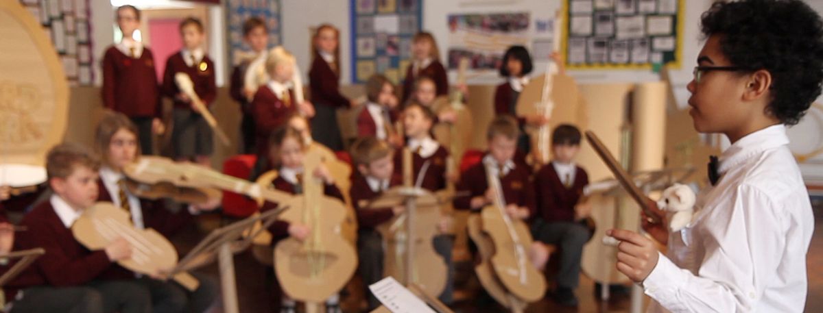 Children playing cardboard instruments 