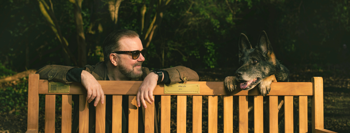 Ricky Gervais and his dog beside a bench to promote Netflix Hope is everything campaign