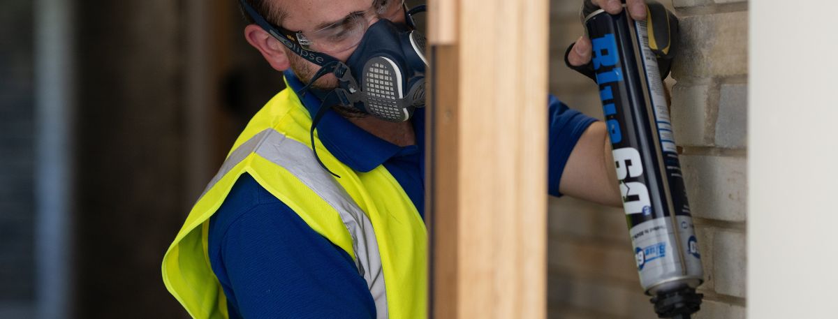 A Harmony Fire worker fitting a fire door