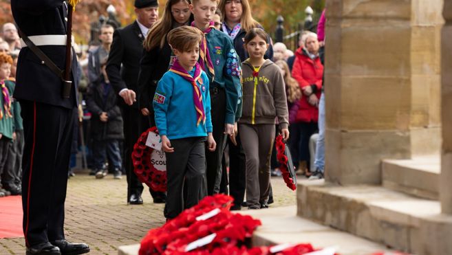 Young person paying tribute at Ashford Remembrance service 2025