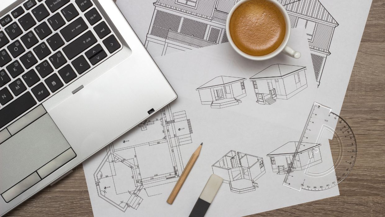 laptop, house drawings and a hot drink