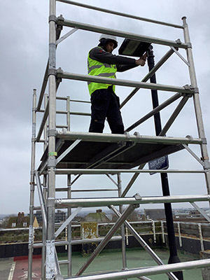 Image entitled Electrician Stood On Scaffolding Fixing A Street Light